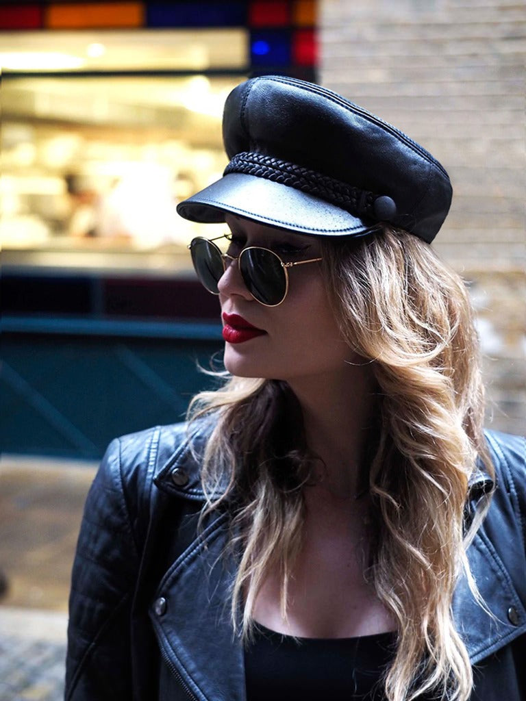 young woman wears john lennon leather cap and leather jacket