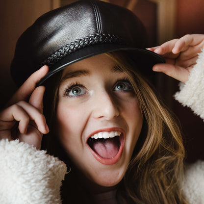 young woman wearing john lennon leather cap